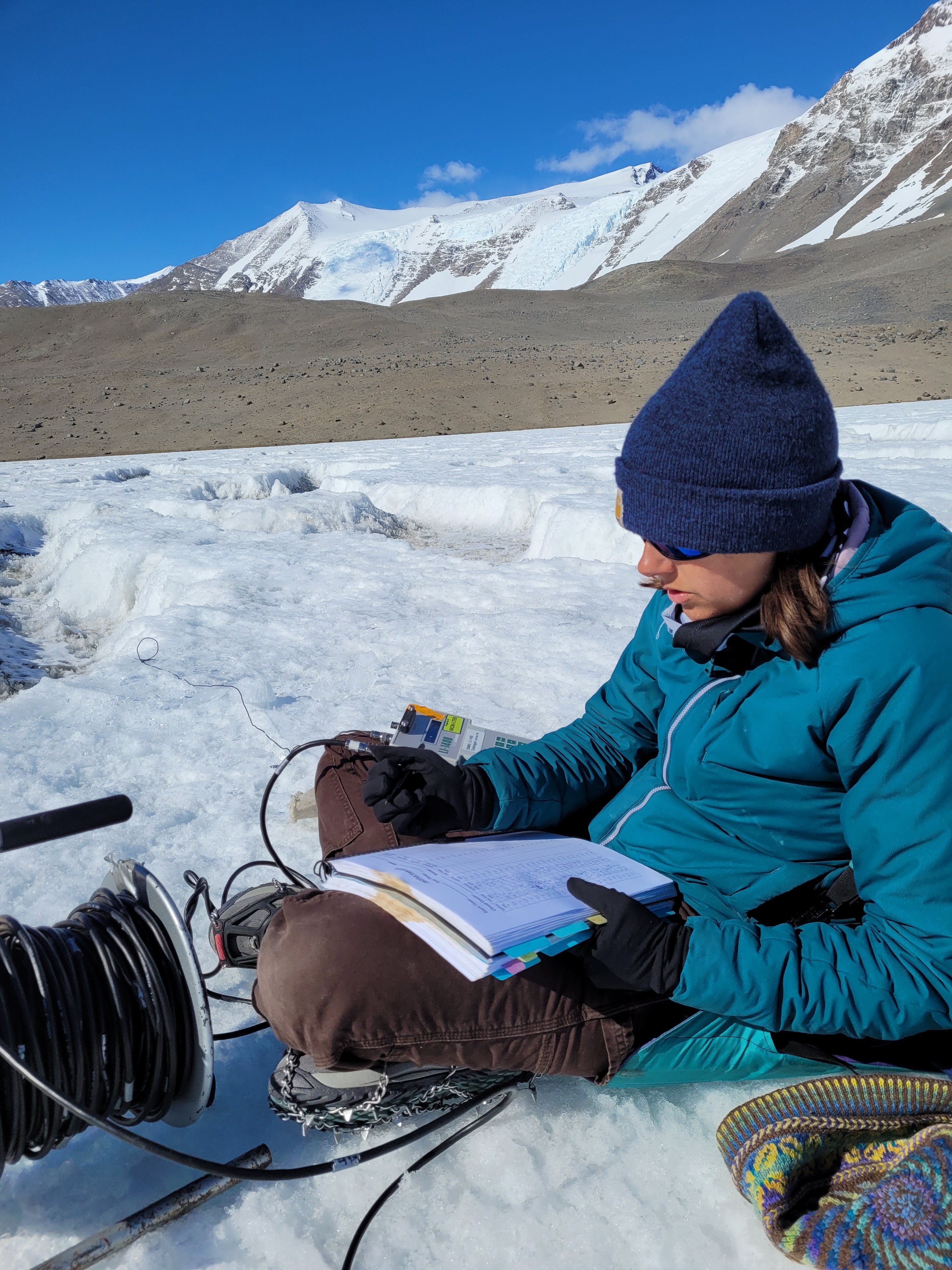 graduate student takes measurements in glacier in Alaska